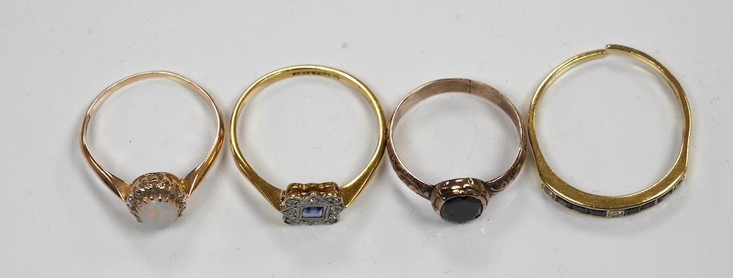 Four assorted gem set rings, including 18ct and plat, sapphire and diamond cluster, 14k, white opal and diamond cluster, an 18ct sapphire and diamond (cut) and an antique garnet set yellow metal ring. Condition - poor to